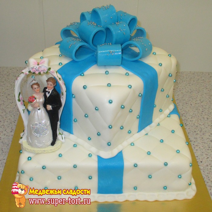 Свадебный торт с голубым бантом и голубыми бусинами